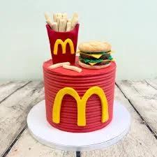 Red McDonald's themed birthday cake with fondant burger and fries toppers and the golden arches logo on the side.