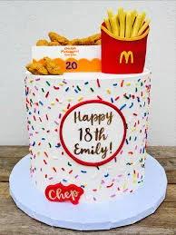 White 1-tier birthday cake with colorful sprinkles, McDonald's fries and chicken nugget toppers for an 18th birthday.