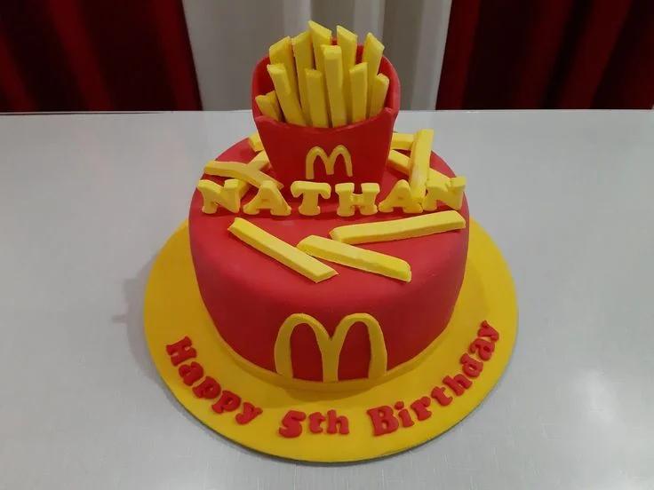 Red McDonald's themed fondant cake with yellow French fry toppers and a large yellow M logo on the side.
