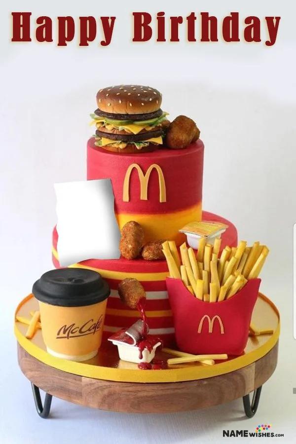 Two-tier McDonald's themed cake featuring a fondant burger, nuggets, fries, and a McCafe cup on a red and yellow striped base.