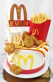 McDonald's themed birthday cake with realistic fries, nuggets, and a drink cup topper on white icing with red and yellow accents.