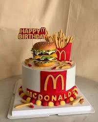 McDonald's themed birthday cake with a 3D burger, fries, and iconic red and yellow branding on white icing.