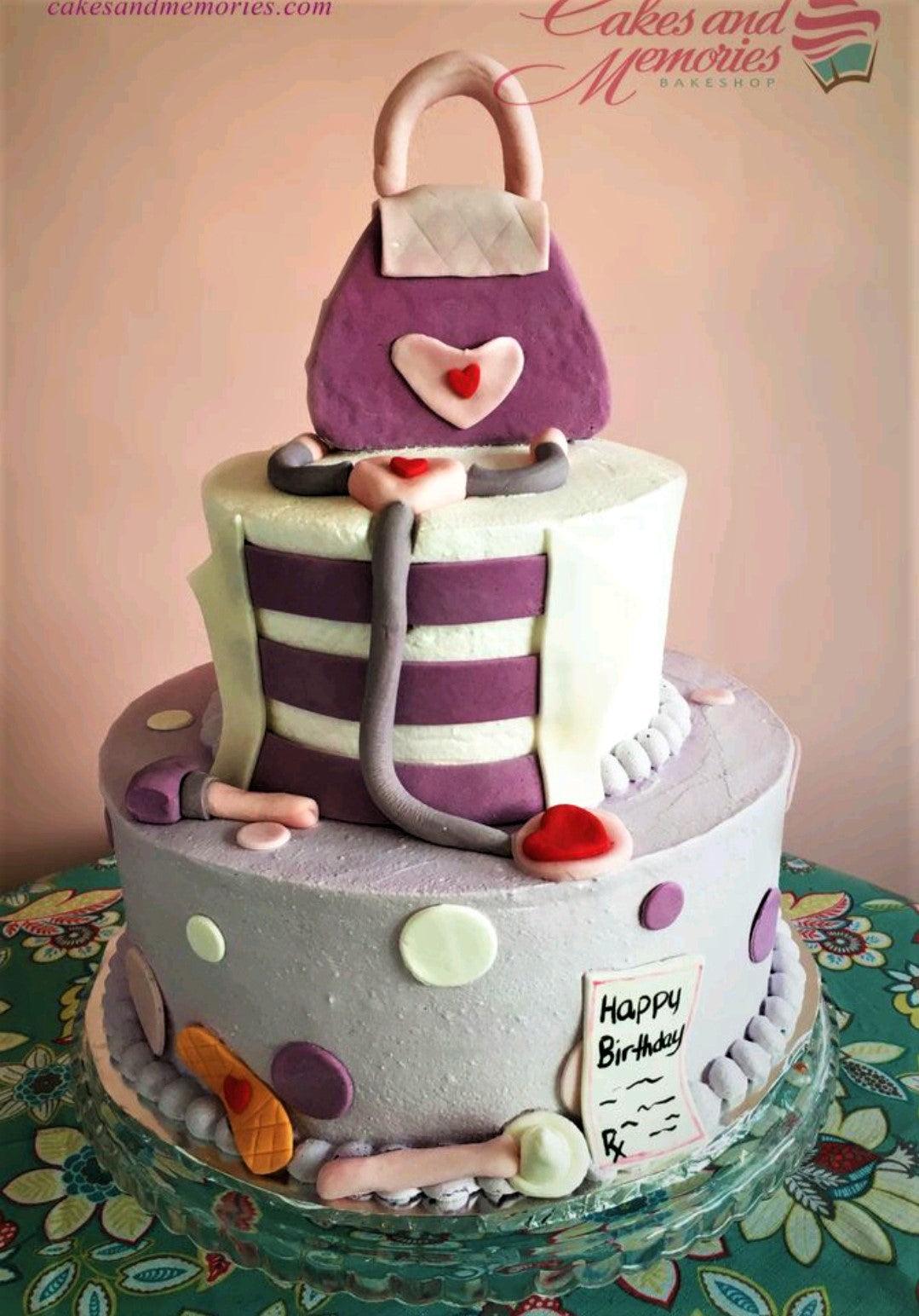 Two-tier purple and white medical-themed cake featuring a fondant doctor's bag, stethoscope, and medical supplies.