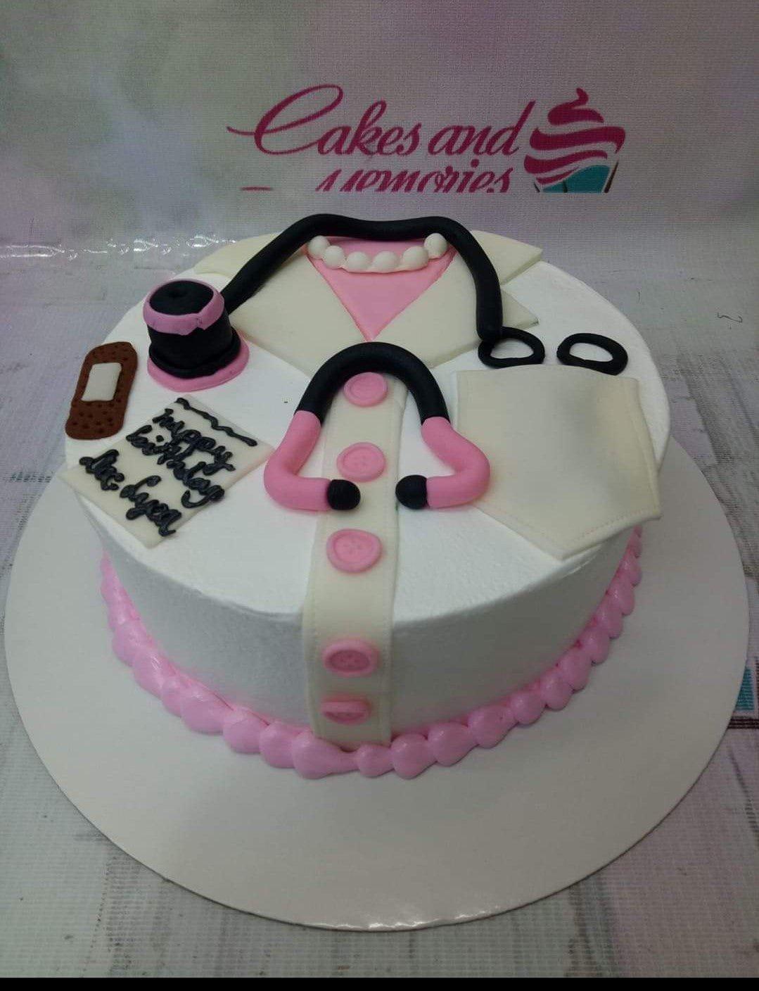 White medical themed cake with pink accents featuring a fondant stethoscope, doctor's coat design, and a mobile phone topper.