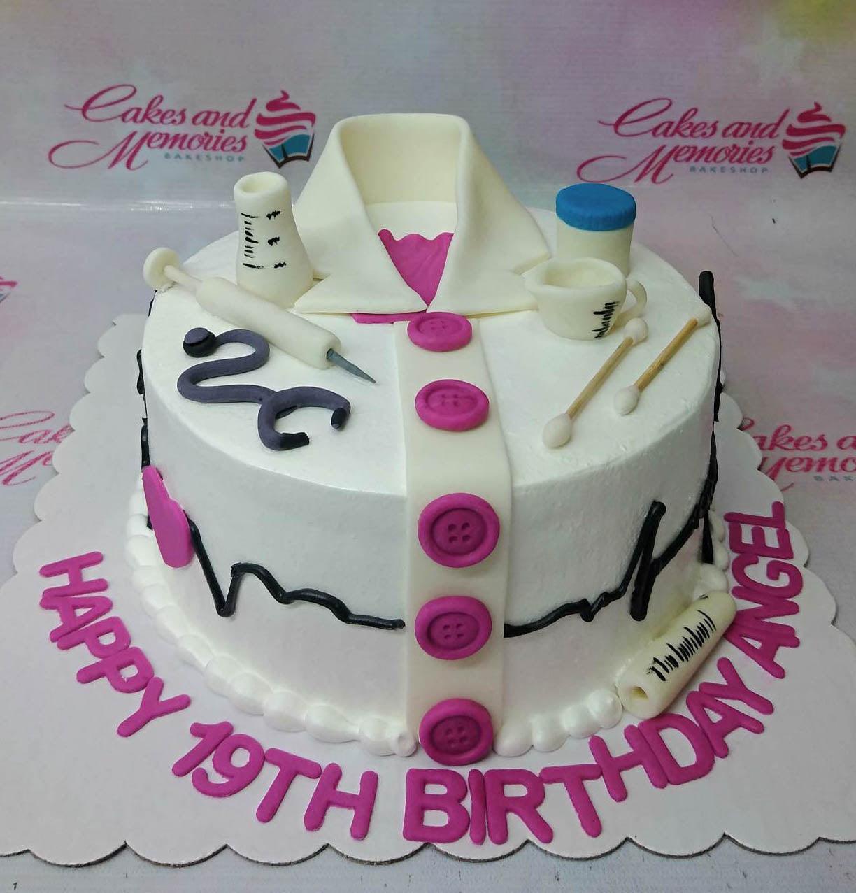 White medical themed birthday cake with fondant doctor's coat, stethoscope, syringe, and medical tools for a 19th birthday.
