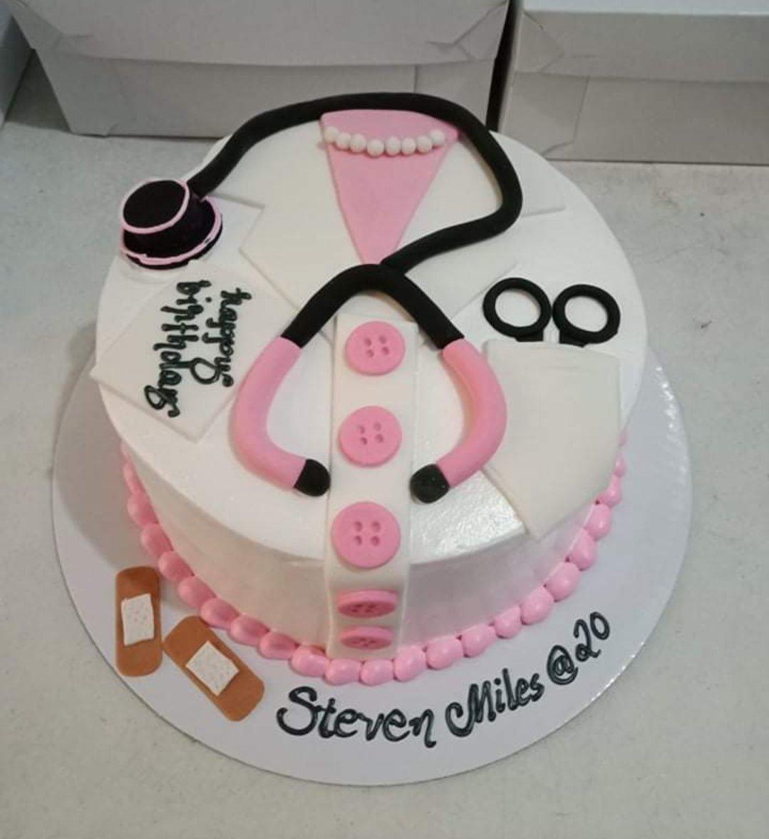 White medical themed cake with pink stethoscope, doctor's coat design, and pink icing border.