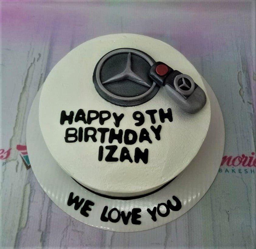 White minimalist Mercedes-Benz themed birthday cake with a 3D fondant car key and logo topper.