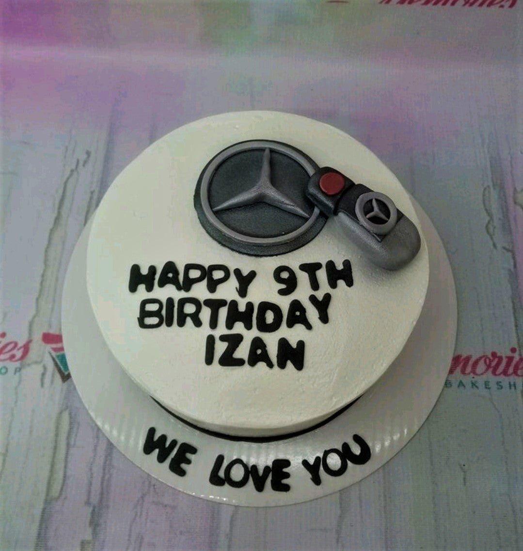 White minimalist Mercedes-Benz themed birthday cake with a 3D fondant car key and logo topper.