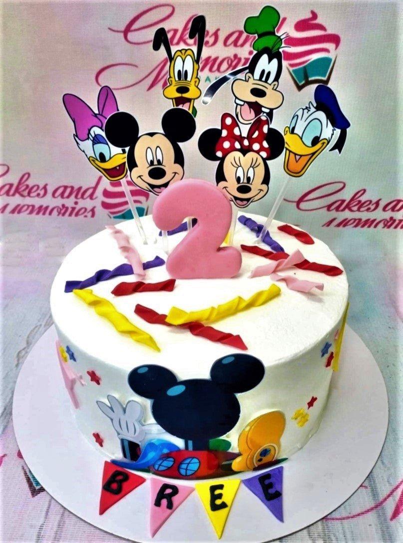 White 1-tier Mickey Mouse and Friends birthday cake with colorful fondant streamers and character printouts.