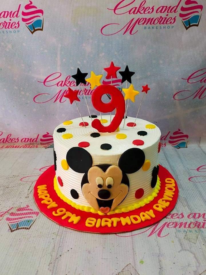 White 1-tier Mickey Mouse birthday cake with red, yellow, and black polka dots and star toppers.