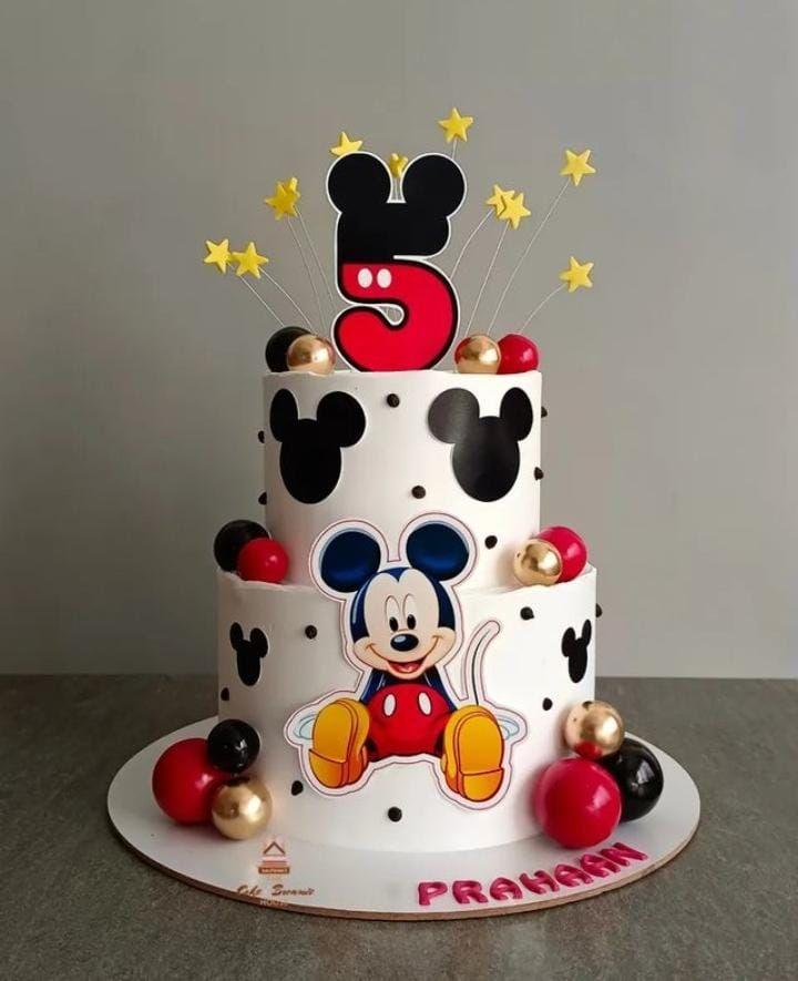 White 2-tier Mickey Mouse birthday cake with red, black, and gold spheres, Mickey silhouettes, and a large number 5 topper.
