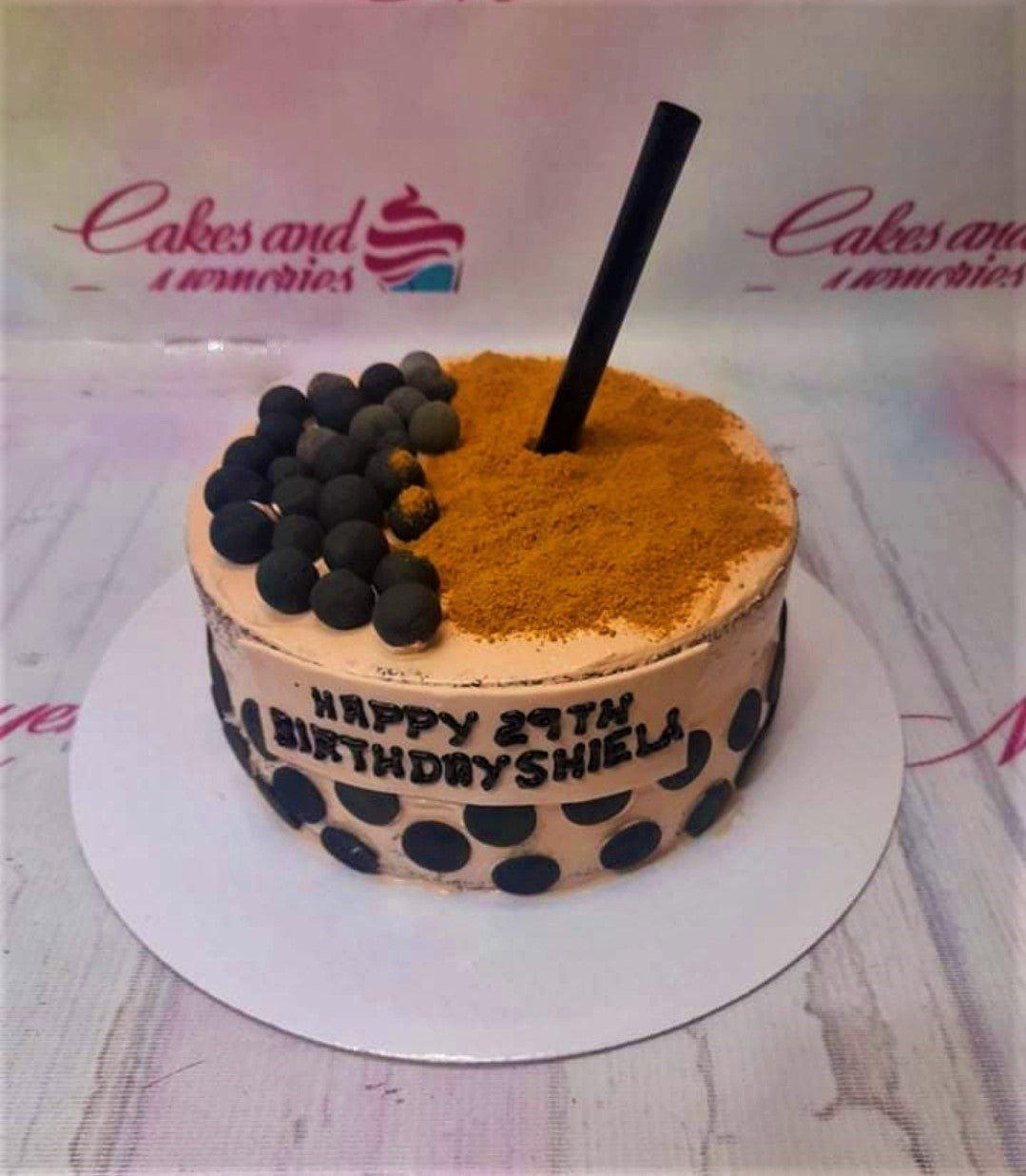 Milk tea themed birthday cake with black boba pearls, brown sugar powder, and a black straw topper.