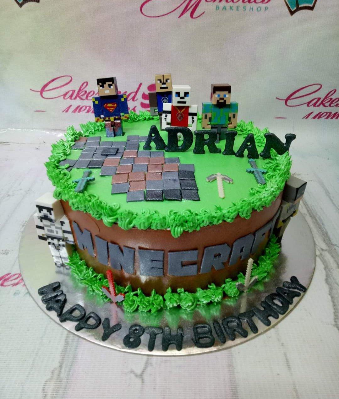 Minecraft themed birthday cake with green grass icing, brown sides, and 3D character toppers for Adrian's 8th birthday.