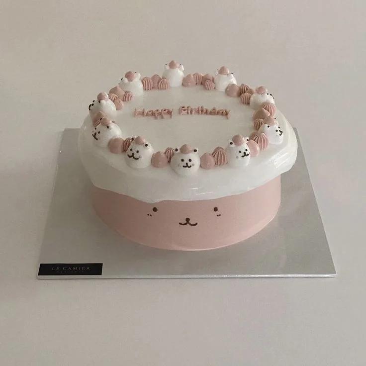 Pink and white minimalist bear cake with small bear icing decorations and Happy Birthday message