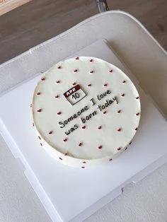 White minimalist bento cake with red heart icing decorations and a calendar printout for April 10.