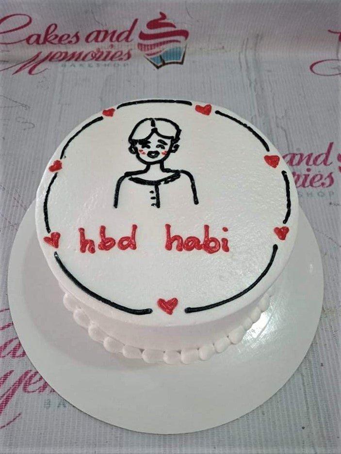 White bento cake with a hand-drawn black icing doodle of a person and red hearts, featuring the message 'hbd habi' in red icing.