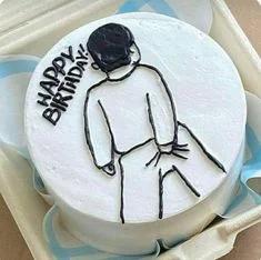 White bento cake with a minimalist black icing doodle of a person and Happy Birthday message.