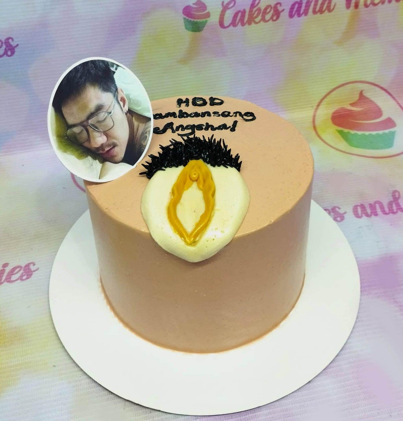 Peach-colored minimalist cake with a photo printout of a man and a unique yellow and black icing decoration on the side.
