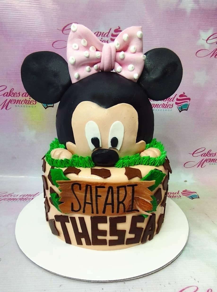 Minnie Mouse Safari themed cake with a large 3D Minnie head topper, giraffe print fondant, and green icing grass.