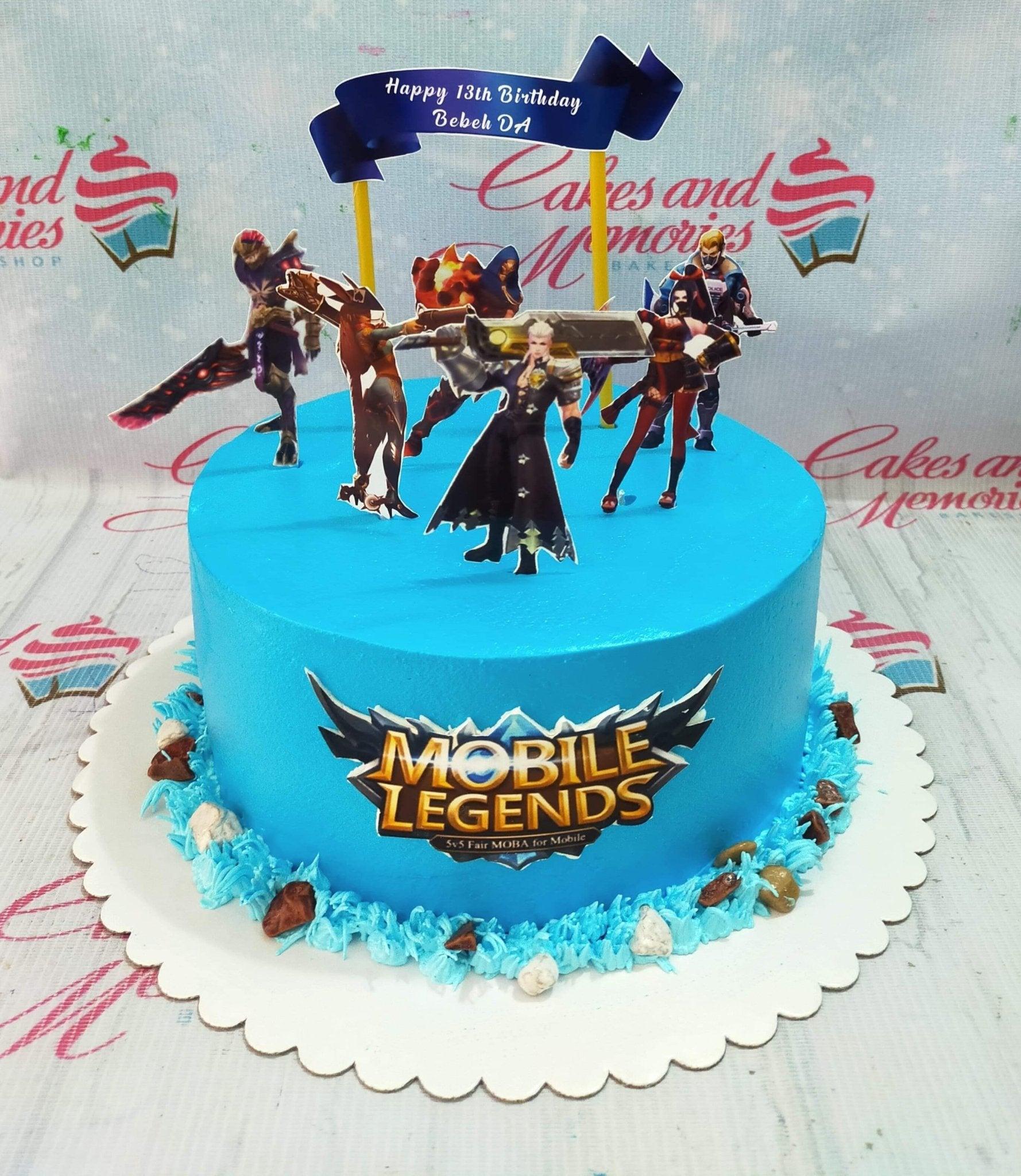 Blue Mobile Legends themed birthday cake with character printouts and a blue banner topper.