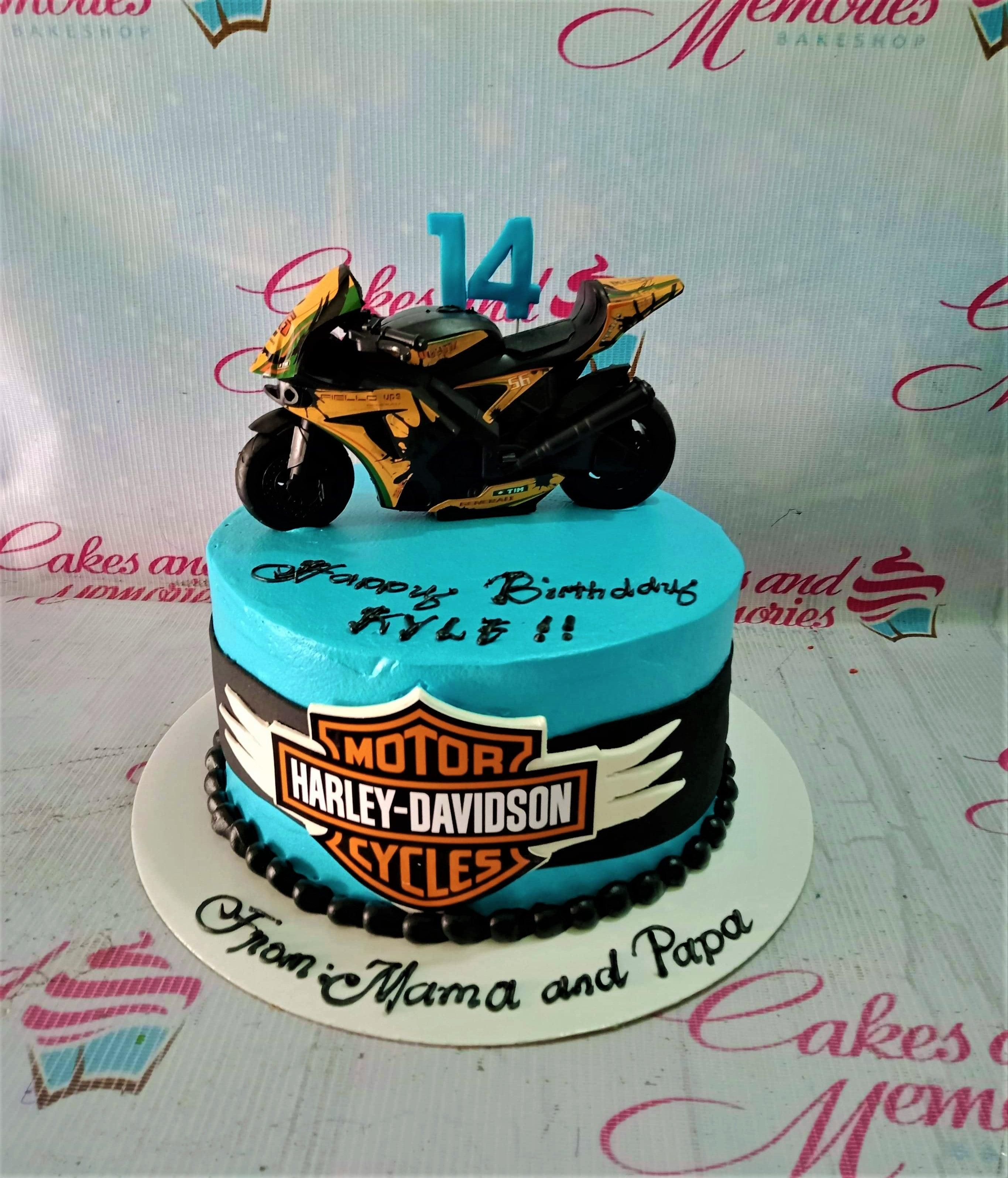 Blue motorcycle themed birthday cake with a large black and yellow sportbike toy topper and Harley-Davidson logo on the side.