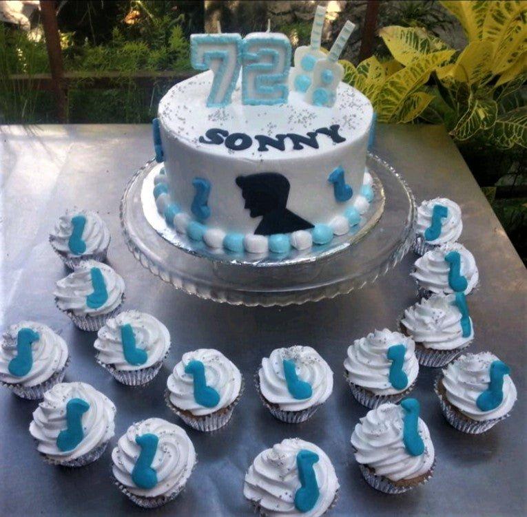 White 1-tier music themed birthday cake with blue and white icing borders, a black silhouette, and blue music note cupcakes.