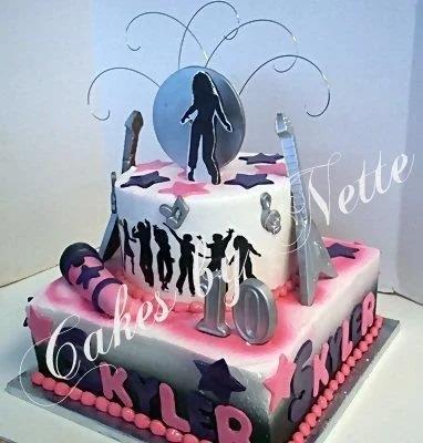 Two-tier music and dance themed cake with black silhouettes of dancers, silver guitars, and a microphone on a pink and white airbrushed base.