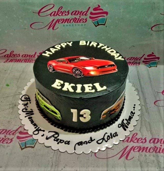 Black car themed birthday cake with red Mustang printout and white icing text for a 13th birthday.