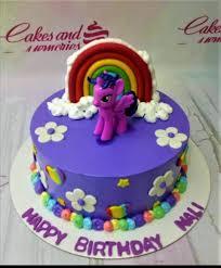 Purple My Little Pony cake with Twilight Sparkle figure, fondant rainbow, and white icing flowers