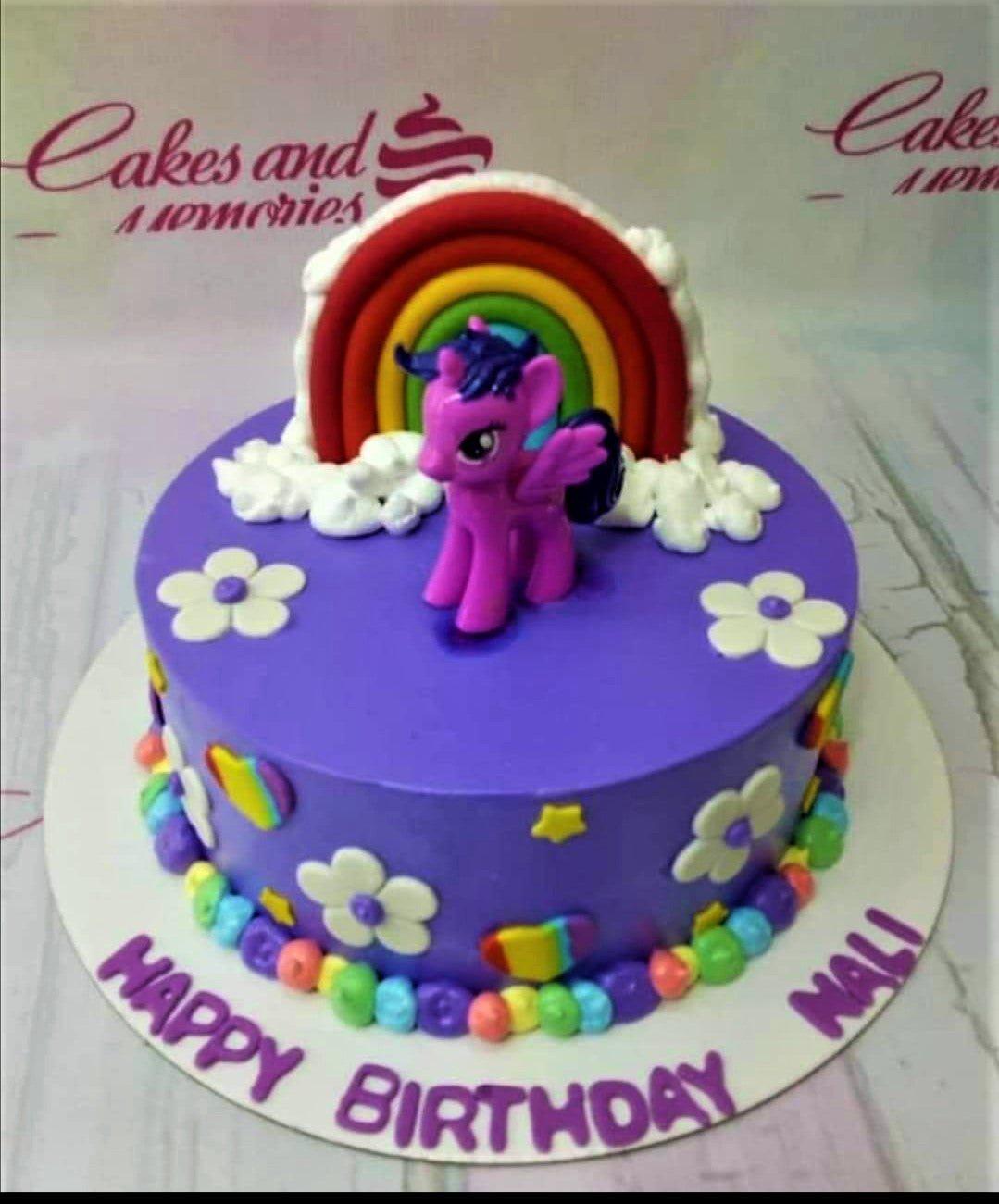 Purple My Little Pony birthday cake with a 3D Twilight Sparkle figure, a fondant rainbow, and white clouds.