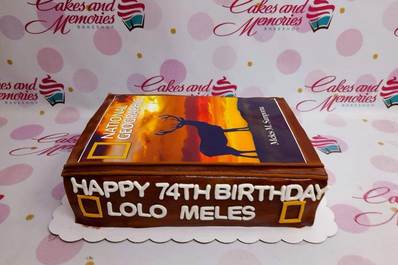 National Geographic themed rectangle cake with a sunset deer printout and Happy 74th Birthday Lolo Meles message.