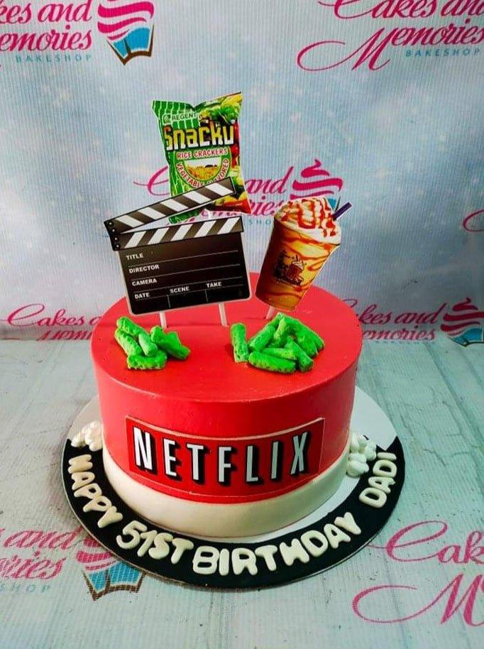 Netflix themed birthday cake with red icing, Snacku and frappe printouts, and green gumpaste snacks on top.