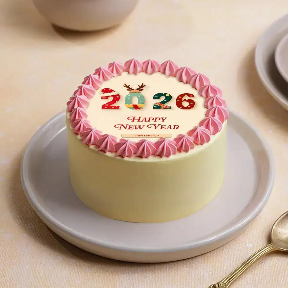 Cream colored New Year 2026 cake with pink icing rosettes and festive printed numbers and message.