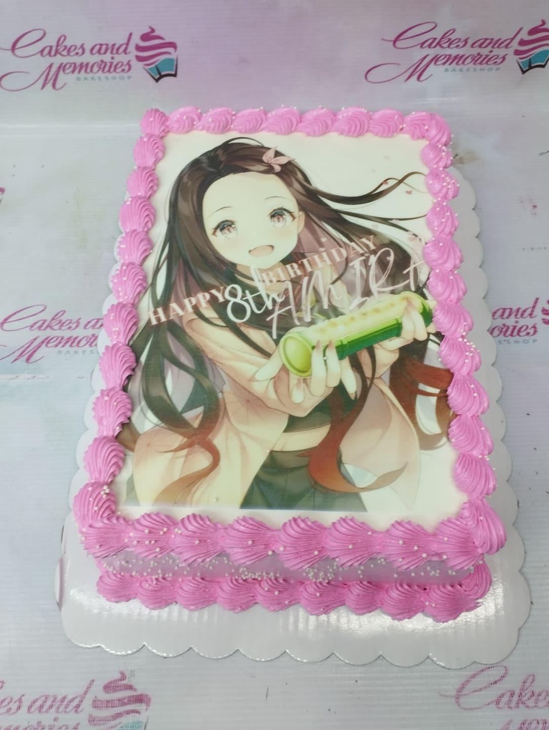 Nezuko Kamado anime character edible print cake with pink icing rosettes and white sprinkles.