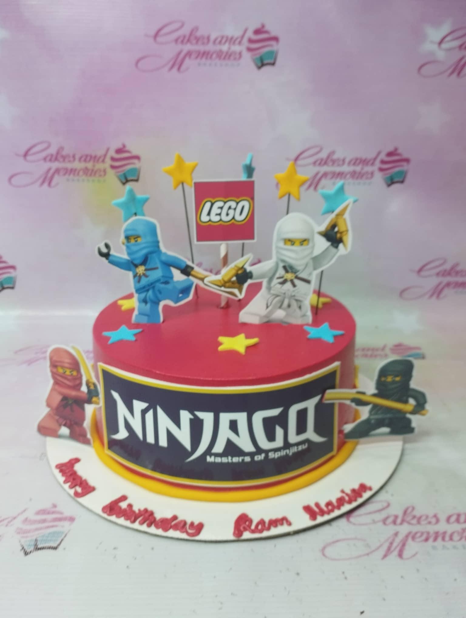 Red Ninjago themed birthday cake with Lego character printouts and yellow and blue stars.