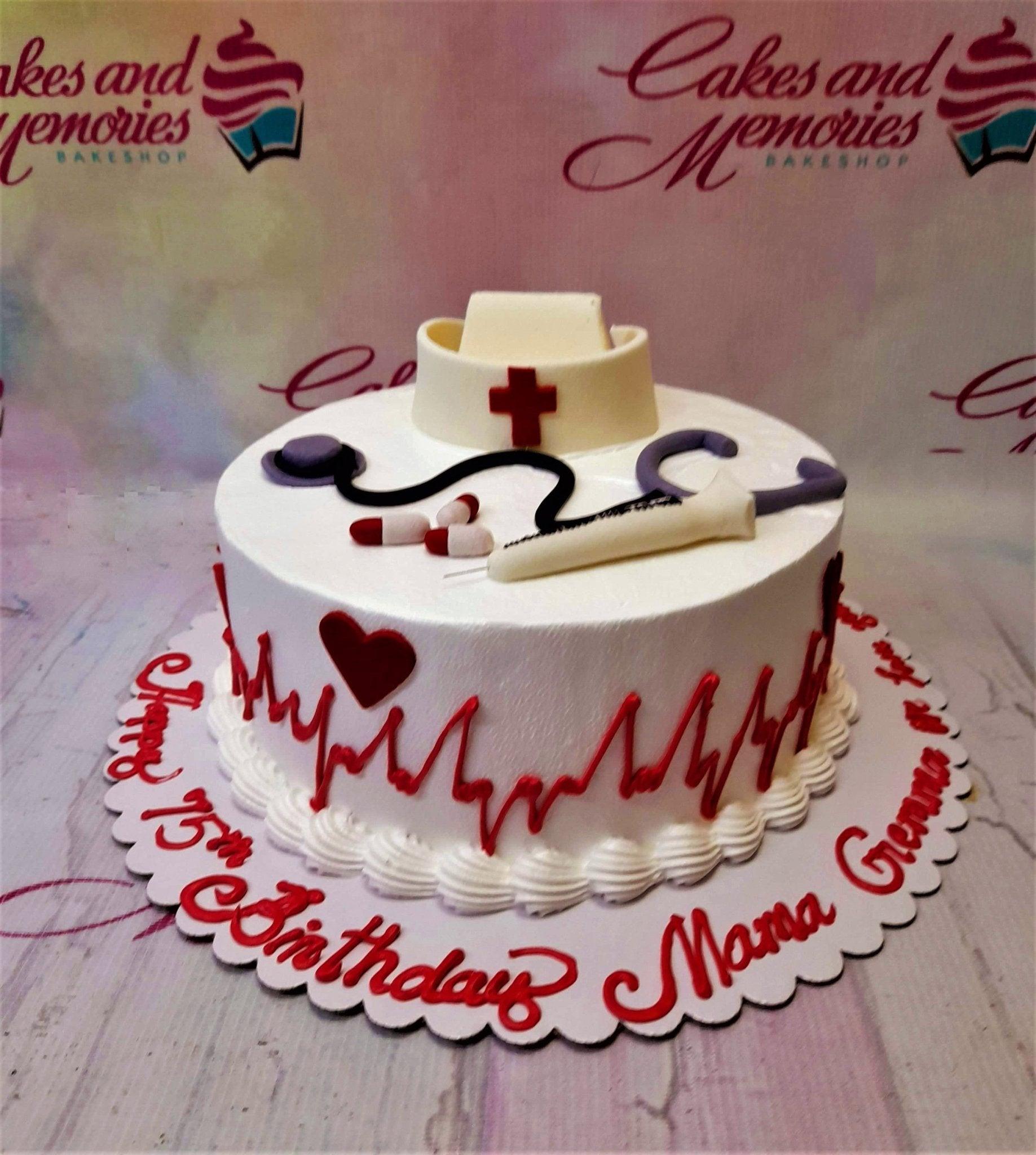 White nurse themed birthday cake with a fondant nurse cap, stethoscope, syringe, and red heartbeat line icing design.