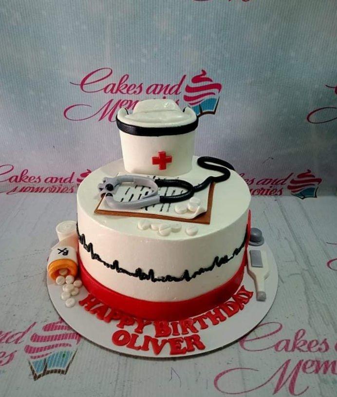 White nurse themed birthday cake with a fondant nurse cap, stethoscope, medical chart, and red base border.