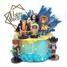 One Piece themed birthday cake with blue icing, gold drip, and various character figurines including Luffy, Zoro, and Chopper.
