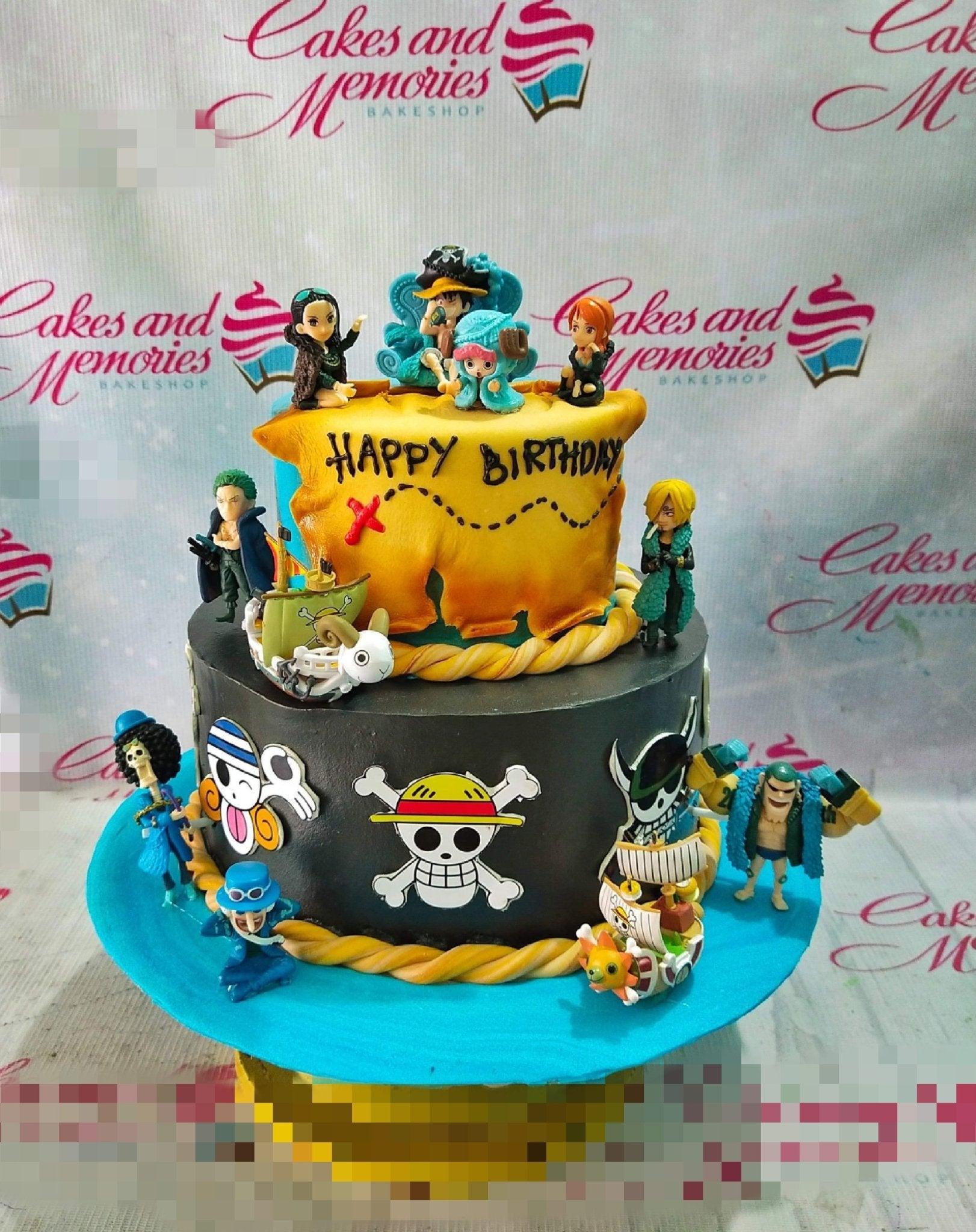 Two-tier One Piece anime themed cake with black and yellow fondant, featuring various character figurines and a treasure map design.