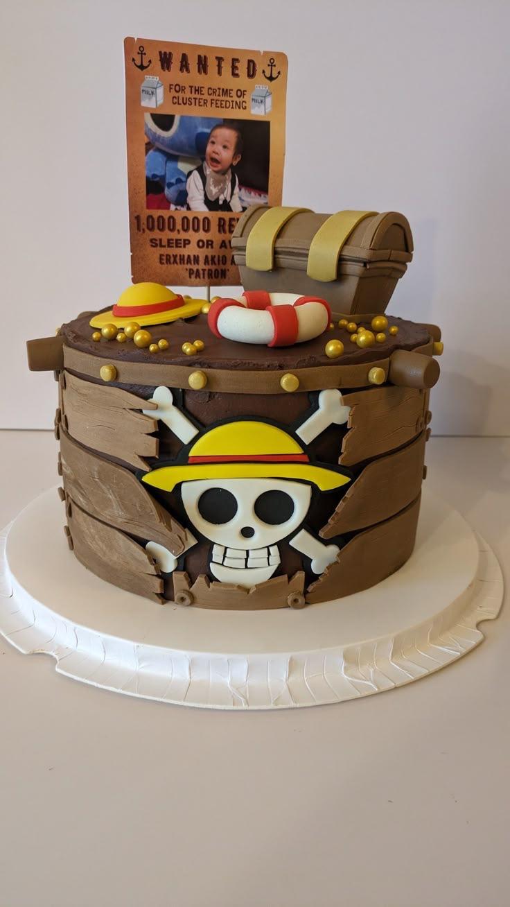 One Piece themed pirate barrel cake with a treasure chest, lifebuoy, and a custom Wanted poster topper.
