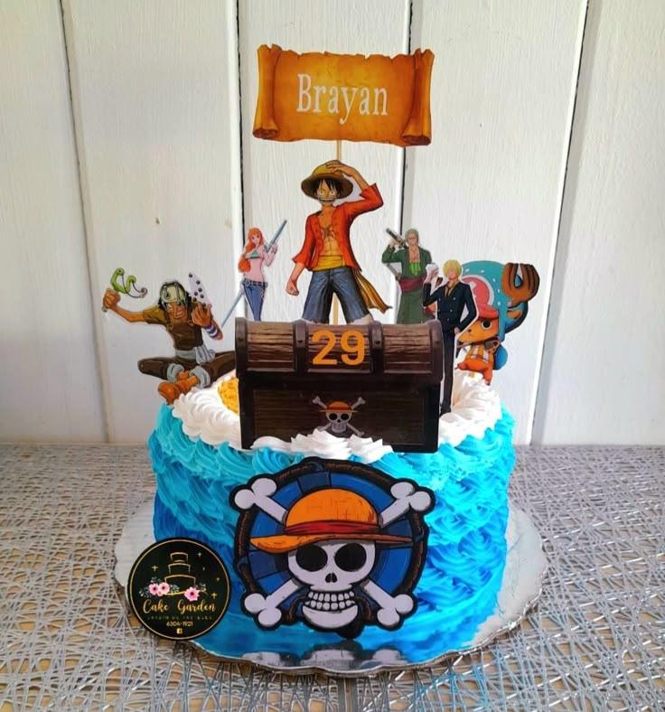 One Piece themed birthday cake with blue ruffled icing, featuring Luffy and the Straw Hat crew printout toppers and a treasure chest.