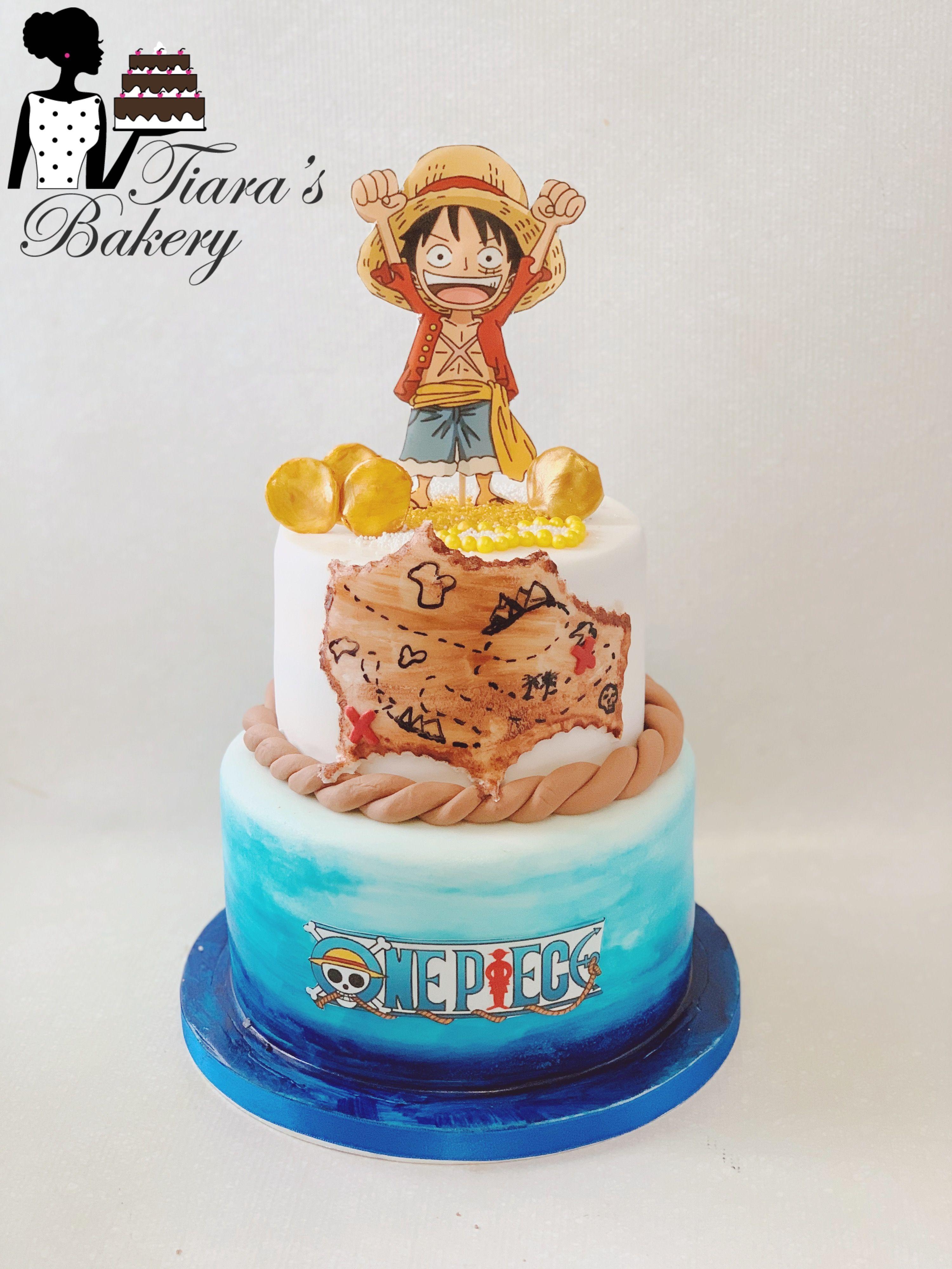 Two-tier One Piece themed cake with Luffy topper, treasure map design, and blue ocean gradient icing.