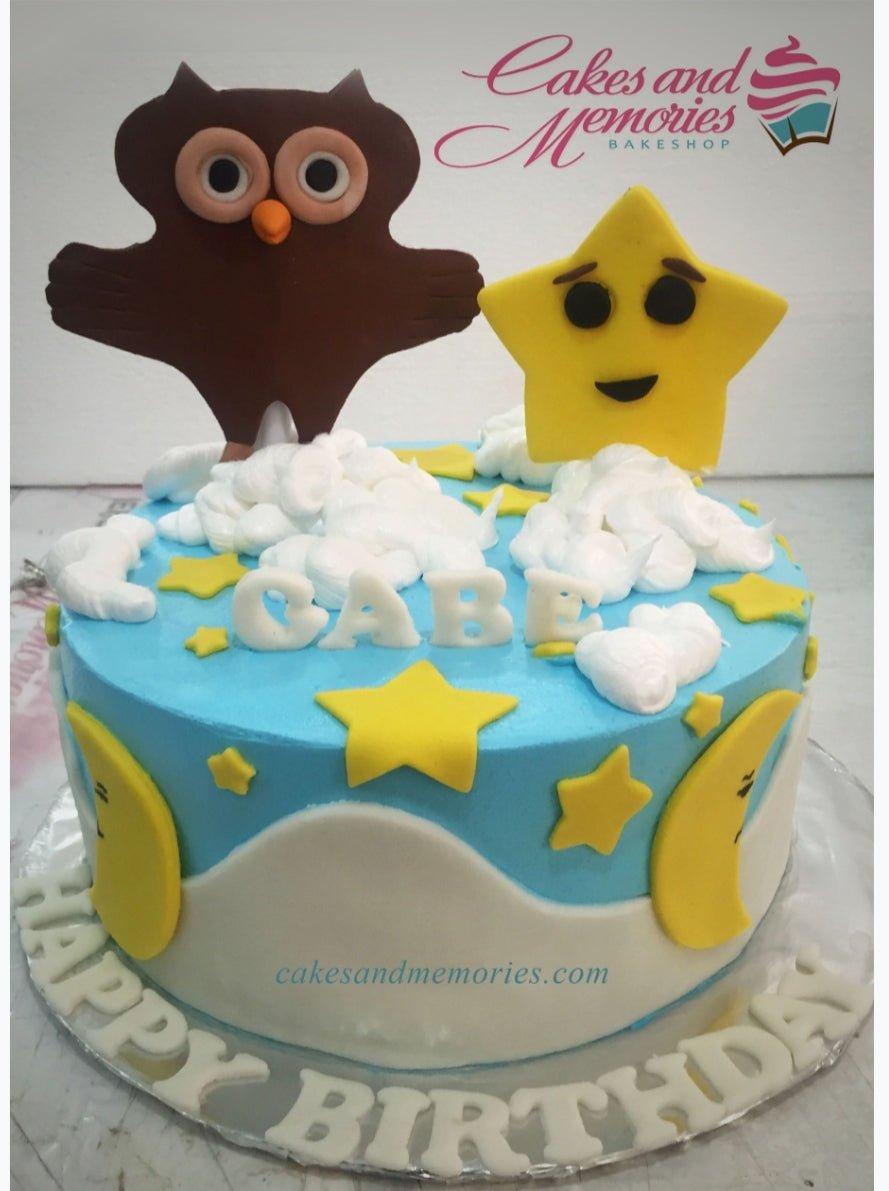 Light blue owl and star themed birthday cake with white icing clouds and yellow fondant stars and moons.
