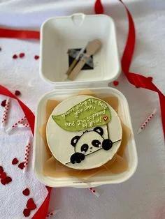 Bento cake in a white box featuring a hand-piped panda and a green leaf with a supportive message.