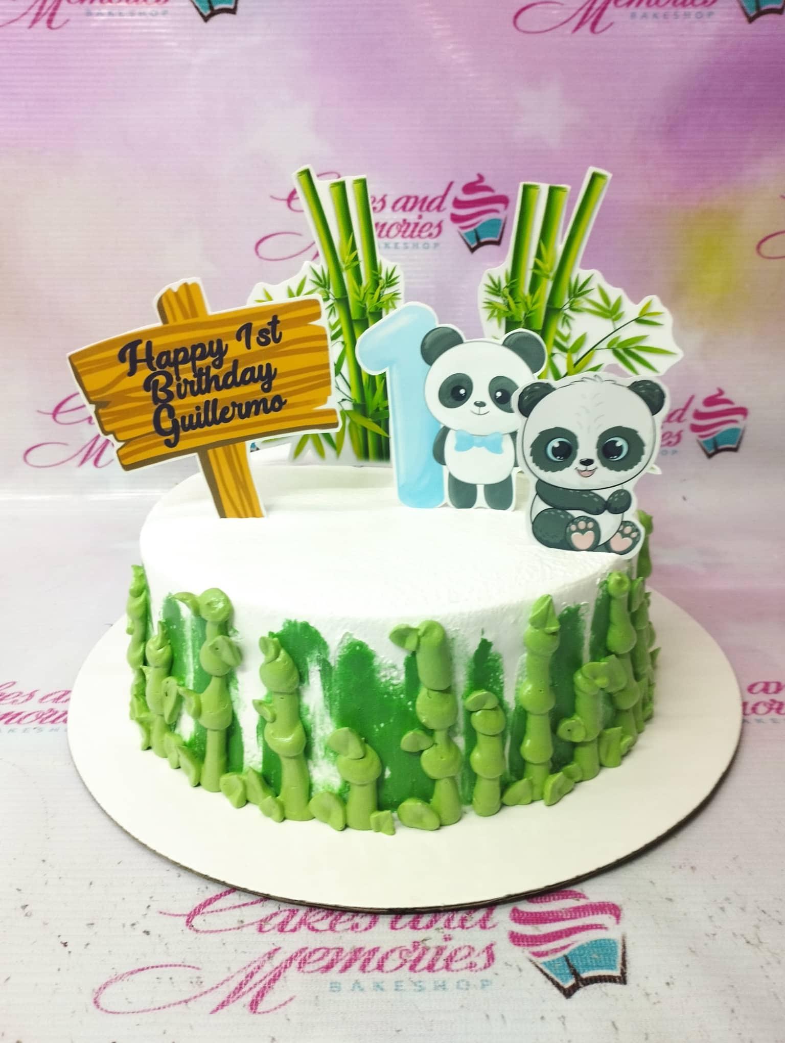 White 1-tier panda birthday cake with green bamboo icing decorations and panda printout toppers.