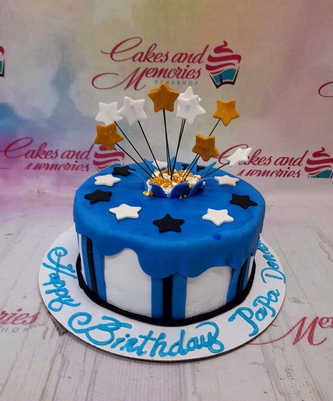 Blue and white striped fondant cake with gold and white gumpaste stars on wires and a Happy Birthday Papa Don message.
