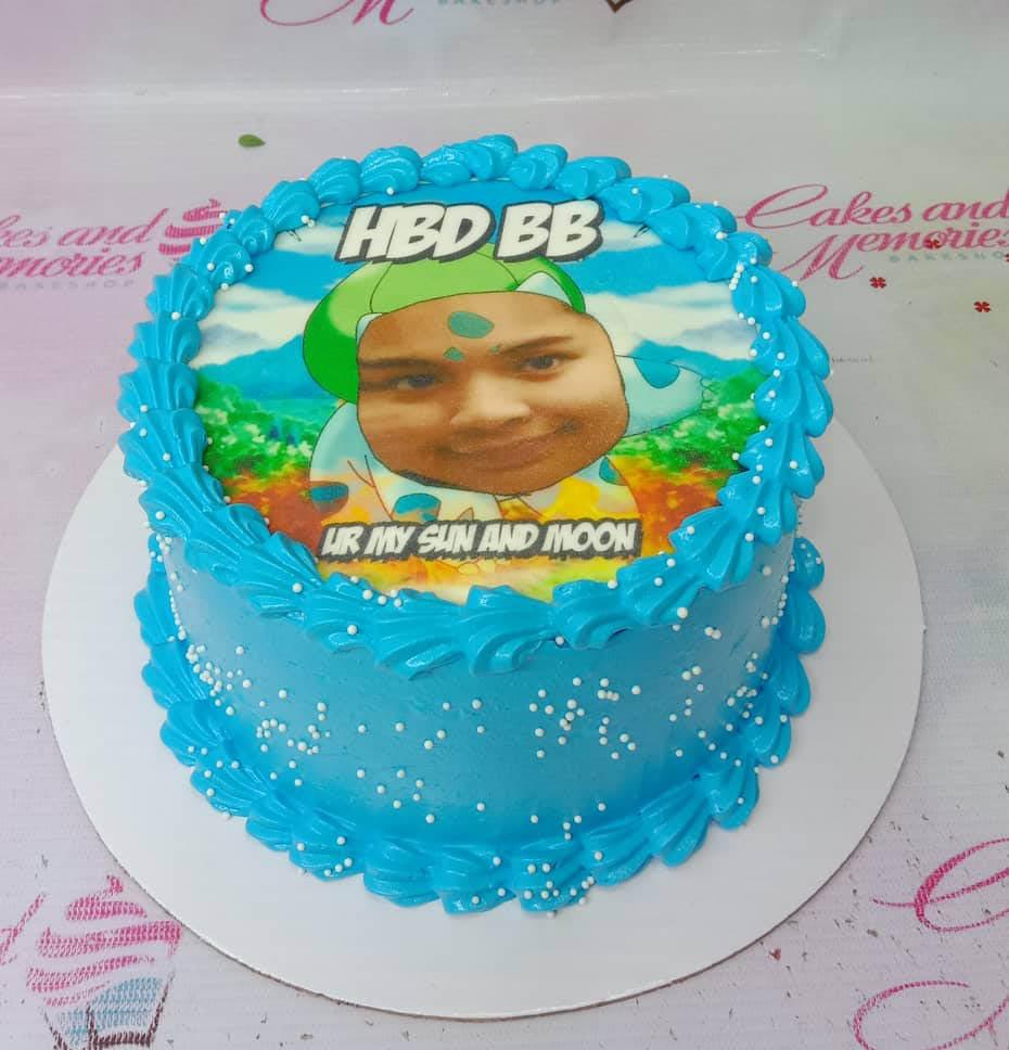 Blue soft-icing birthday cake with a large edible photo print of a person in a green hat and white pearl sprinkles.