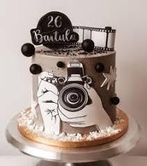 Grey 1-tier cake with camera and film strip printouts, black spheres, and a custom name topper