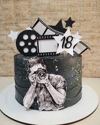 Black textured cake with a photographer cutout, film strip toppers, and stars for an 18th birthday.