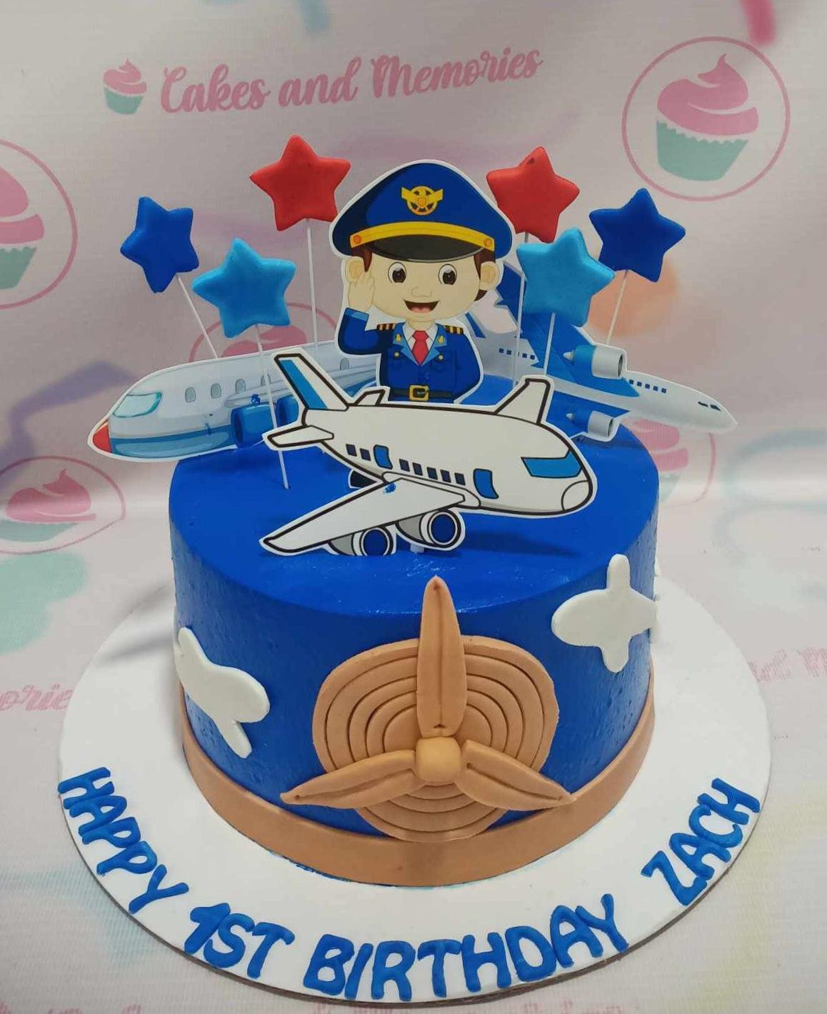 Blue pilot themed birthday cake with airplane printouts and a large gumpaste propeller on the side.
